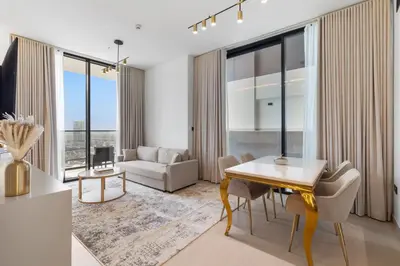 a living room with a dining table and a couch at Your Own Pool Spacious 2BDR Apartment JVC in Dubai