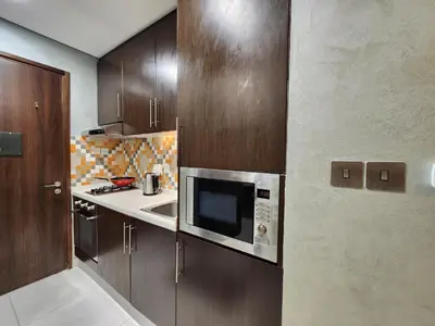 a kitchen with a microwave and a sink at Bright Beachfront Studio with Breathtaking Views in Dubai