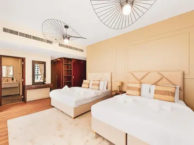 a bedroom with two beds and a mirror at New! JBR Beachfront with Panoramic Dubai Eye Views in Dubai