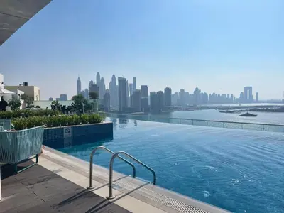 a swimming pool with a city skyline in the background at The Palm Hideaway Chic Apartment with Rooftop Vibes Managed by SunnyHomes in Dubai
