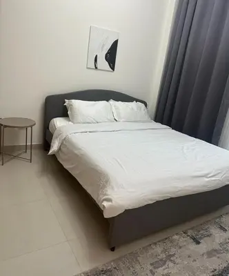 a bed with white sheets and pillows in a bedroom at Enjoy Sunset at Creek Beach in Dubai
