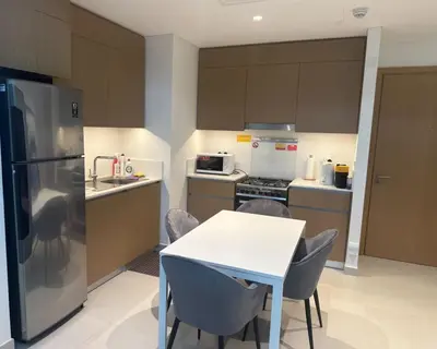 a kitchen with a table and a refrigerator at Enjoy Sunset at Creek Beach in Dubai