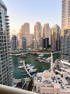 a view of a city with boats in a harbor at Cozy Home w Spectacular Water View in Dubai