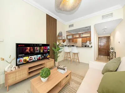 a living room with a television and a couch at Cozy Home w Spectacular Water View in Dubai