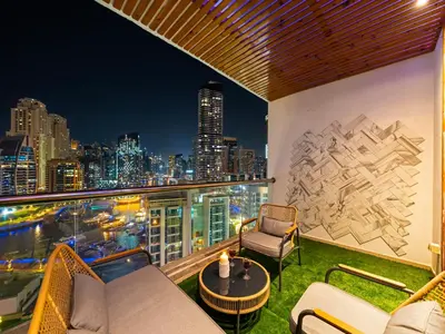 a balcony with a view of the city at night at Luxurious 2BR Apt with Marina View & Private Jacuzzi in Dubai