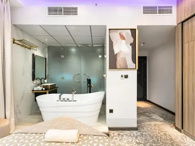 a bathroom with a large tub and a sink at Luxurious 2BR Apt with Marina View & Private Jacuzzi in Dubai