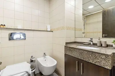 a bathroom with a sink and a toilet and a mirror at Silkhaus Dubai Marina 1BR in Bay Central West Tower in Dubai
