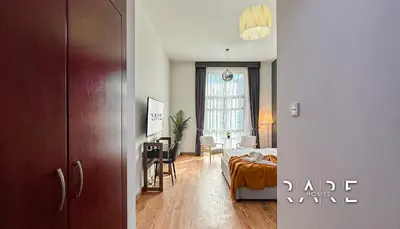 a bedroom with a bed and a living room at Rare Holiday Homes - Mediterranean Cluster - Near Ibn Battuta Mall - Discovery Garden - Building# Med 38 - RG04 in Dubai