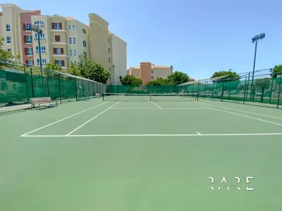 a tennis court in front of a building at Rare Holiday Homes - Mediterranean Cluster - Near Ibn Battuta Mall - Discovery Garden - Building# Med 38 - RG04 in Dubai
