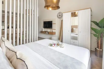 a bedroom with a large white bed and a tv at Frank Porter - Rokane G22 in Dubai