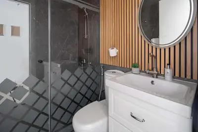 a bathroom with a toilet and a sink and a mirror at Frank Porter - Rokane G22 in Dubai