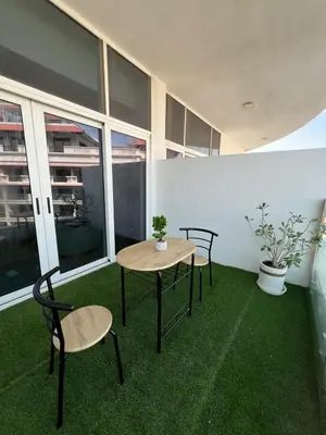 a table and chairs in a room with green grass at Cozy Home with Beach Access in Palm Jumeirah in Dubai