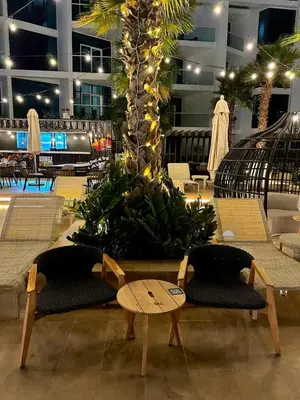 a lobby with a palm tree with chairs and a table at Luxury Studio Apartment in Downtown Dubai in Dubai