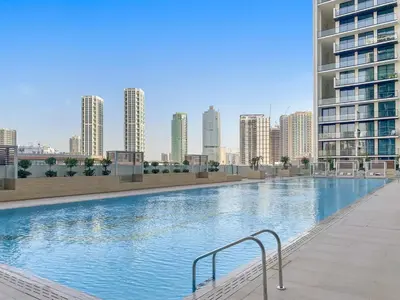 a large swimming pool in a city with tall buildings at FIRST CLASS 1BR Cozy Urban Getaway in Dubai
