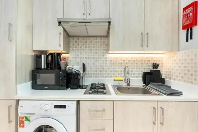 a kitchen with a sink and a washing machine at Luxurious Studio In Seven Palm - Direct Beach Access in Dubai