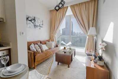 a living room with a couch and a large window at Full burj khalifa view 1bhk app in Dubai