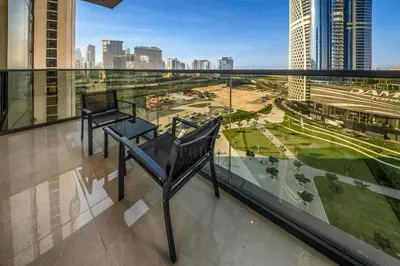 a chair on a balcony with a view of a city at Spacious & Elegant 1BD, for 2 in Nobles tower in Dubai