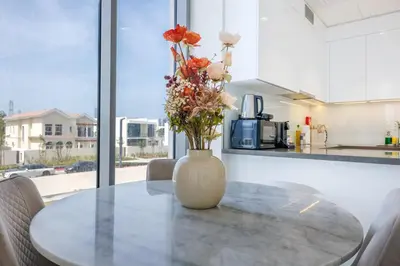 a vase with flowers on a table in a kitchen at Charming 1 Bedroom Apt in MBR - Near Downtown Dubai in Dubai