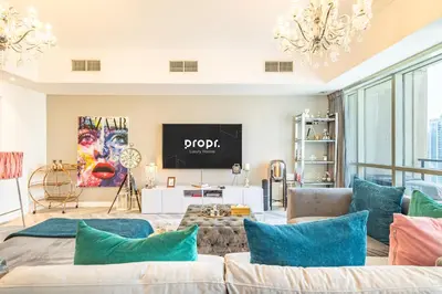 a living room with a couch and a tv at Serene 2BR Escape - Al Majara - Waterfront Stay in Dubai