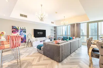 a living room with a large couch and a table at Serene 2BR Escape - Al Majara - Waterfront Stay in Dubai