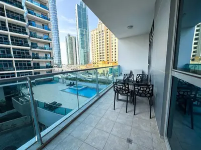 a balcony with a table and chairs and a view of a city at Holiday Homes by DO - Dubai Marina in Dubai