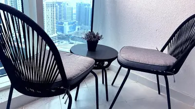 two chairs and a table in front of a window at Bellaviu Holiday Homes- Escape the Buzz-Your Quiet Spot in DAMAC Prive in Dubai