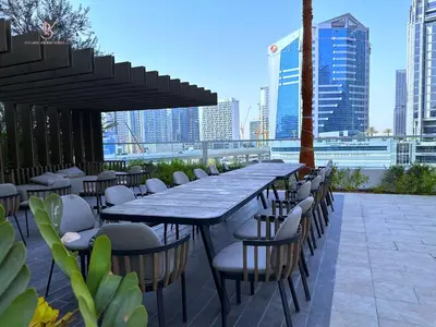 a long table and chairs with a view of the city at Bellaviu Holiday Homes- Escape the Buzz-Your Quiet Spot in DAMAC Prive in Dubai