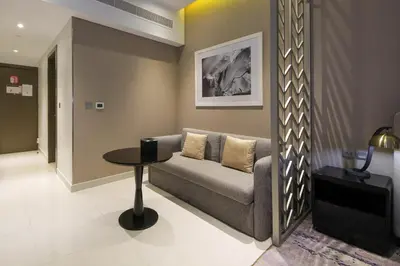 a living room with a couch and a table at Stylish Studio Apartment with pool in Business Bay in Dubai