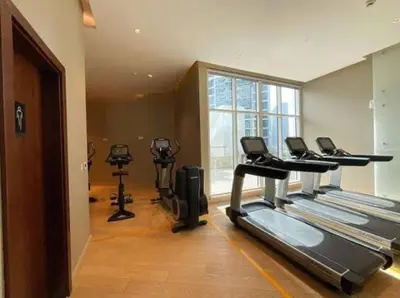 a gym with treadmills and ellipticals in a room at Stylish Studio Apartment with pool in Business Bay in Dubai
