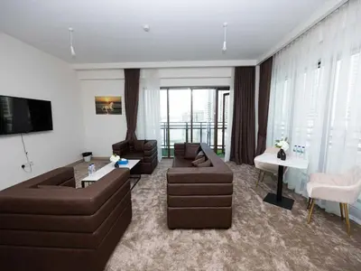 a living room with couches and a table and a television at Sunset Creek Harbour, Dubai in Dubai