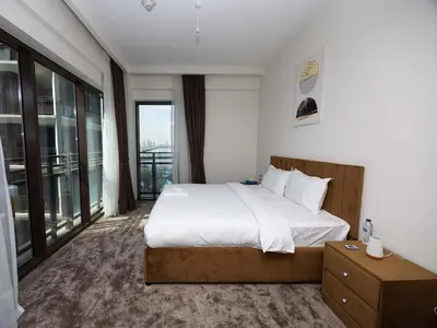 a bedroom with a large bed and a large window at Sunset Creek Harbour, Dubai in Dubai