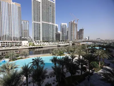 a view of a city with a pool and palm trees at Sunset Creek Harbour, Dubai in Dubai
