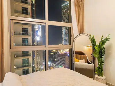 a bedroom with a large window with a view of a city at Luxury 4BR - Full Marina View - High Floor Bliss in Dubai