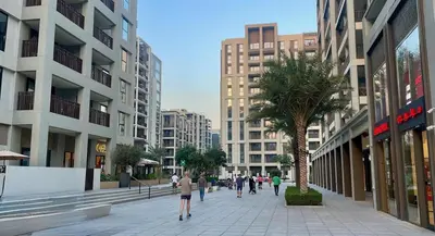 people walking down a sidewalk in a city with buildings at Beachfront Family Entire Unit in Dubai Ras Al-Khor in Dubai