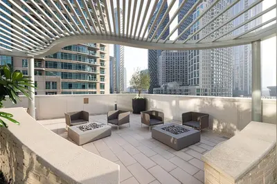 a rooftop patio with furniture and a view of skyscrapers at FORTE Tower 2 - One-Bedroom Apartment in DOWNTOWN Dubai, near Burj Khalifa & Dubai Fountains - Apartment in Forte Tower 2 in Dubai