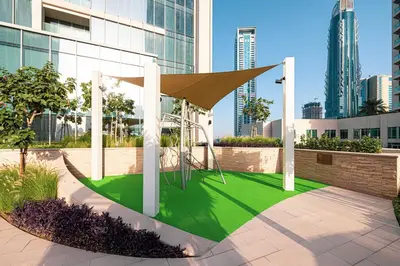 a park with a playground in a city with tall buildings at FORTE Tower 2 - One-Bedroom Apartment in DOWNTOWN Dubai, near Burj Khalifa & Dubai Fountains - Apartment in Forte Tower 2 in Dubai
