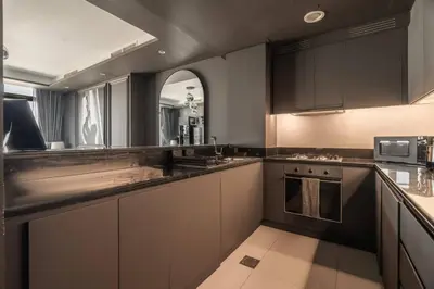 a kitchen with gray cabinets and a counter top at 5 Star Rooftop Infinity Pool with Burj Khalifa Views in Dubai