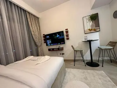 a hotel room with a bed and a flat screen tv at Studio Designer Azizi 41 in Dubai