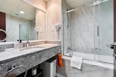 a bathroom with a sink and a shower at Spacious 2 BR With Pool, Gym and Kid's Playground in Dubai
