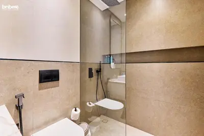 a bathroom with a shower with a toilet and a sink at bnbmehomes - Oxford Terraces in Dubai