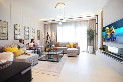 two women sitting on couches in a living room at Elite 4 Bedroom Luxury Apartment, Burj Khalifa View, Opposite Dubai Mall, Infinity Swimming Pool in Dubai