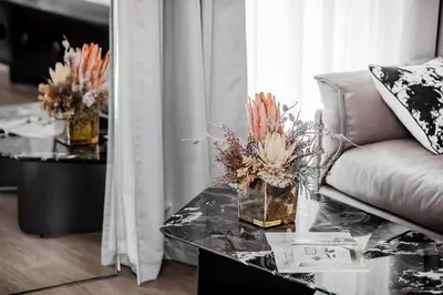 a living room with a couch and a table with flowers on it at Modern Stylish Studio Apartment next to Burj Khalifa walk into Dubai mall in Dubai