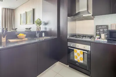 a kitchen with a stove top oven next to a sink at Frank Porter - Damac Distinction in Dubai