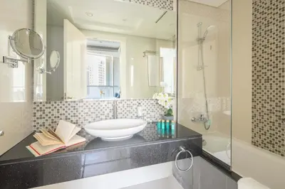 a bathroom with a sink and a mirror and a tub at Frank Porter - Damac Distinction in Dubai