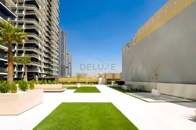 a courtyard in a building with green grass at Close Proximity to Leisure Areas and City View 1BR, Binghatti Corner, Jumeirah Village Circle by Deluxe Holiday Homes in Dubai