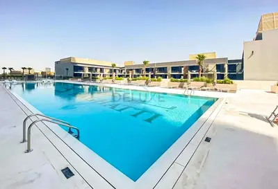a swimming pool at a resort with blue water at Close Proximity to Leisure Areas and City View 1BR, Binghatti Corner, Jumeirah Village Circle by Deluxe Holiday Homes in Dubai