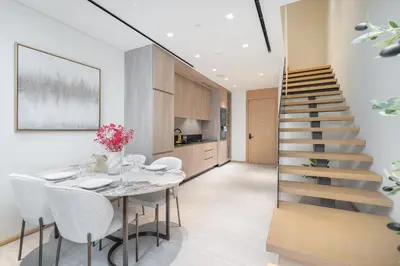 a dining room with a staircase and a table and chairs at Elegant 1BHK by CzechIn Luxe Stay with Pool and Gym in Dubai