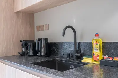 a kitchen counter with a sink in a kitchen at Elegant 1BHK by CzechIn Luxe Stay with Pool and Gym in Dubai