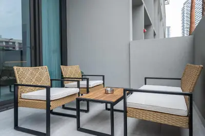 a group of chairs and a table on a balcony at Elegant 1BHK by CzechIn Luxe Stay with Pool and Gym in Dubai