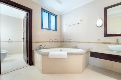 a bathroom with a tub and a sink and a toilet at Beachfront 6BR and Assistant's Room Villa with Private Pool, Palm Villa, Palm Jumeirah by Deluxe Holiday Homes in Dubai
